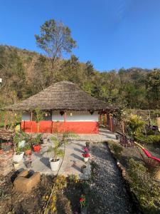 a small house with a thatched roof at Shivoham the earthen Home in Dehradun