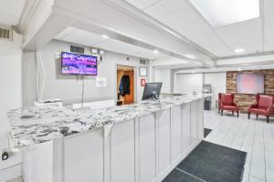 een grote kamer met een grote bar met stoelen bij Red Roof Inn & Suites Fayetteville-Fort Bragg in Fayetteville