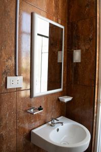 uma casa de banho com um lavatório e um espelho em Morada Apartamentos em Tacna