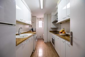 a kitchen with white cabinets and a sink at 3 bedrooms appartement at Calafell 5 m away from the beach with sea view terrace and wifi in Calafell