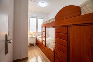a bedroom with a bunk bed with a wooden cabinet at 3 bedrooms appartement at Calafell 5 m away from the beach with sea view terrace and wifi in Calafell