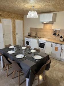 a kitchen with a table with chairs and a dining room at Le champenois in Festigny