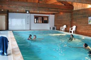 a group of children swimming in a swimming pool at Chalet Pura Vida Morillon Samoëns Grand Massif 6-8 in Morillon