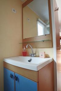 a bathroom with a sink and a mirror at Mobilhome LesPins YourHostHelper in Hyères