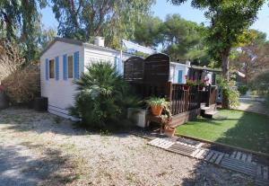 a white tiny house in a yard with plants at Mobilhome LesPins YourHostHelper in Hyères