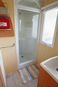 a shower with a glass door in a bathroom at Mobilhome LesPins YourHostHelper in Hyères