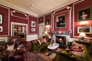 a living room filled with furniture and a fire place at Thainstone House in Inverurie