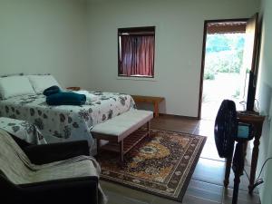 uma sala de estar com uma cama e um sofá em Pousada Campo Redondo em Ibicoara