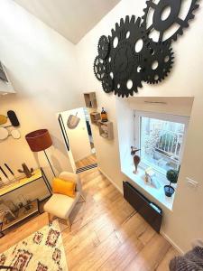 a living room with a chair and a clock on the wall at Le TyTerracotta de juju, en plein cœur de la ville in Saint-Brieuc