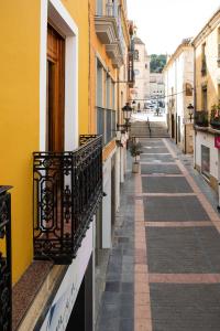 een steeg met een geel gebouw en een balkon bij Alojamiento Yecla Centro by piso del Ayuntamiento de Yecla in Yecla