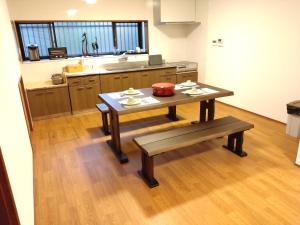 cocina con mesa y banco en 政義の宿, 