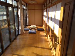 an empty room with windows and a table on the floor at 政義の宿 
