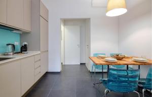 kuchnia z drewnianym stołem i niebieskimi krzesłami w obiekcie Amazing Apartment In Genova With Wifi w Genui +12 zdjęć