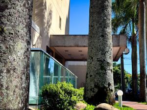 a building with two palm trees in front of it at Hotel Cianorte Diamond in Cianorte