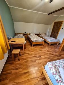 a room with three beds and a table at Karkonoska Drewniana Chata in Kamienna Góra