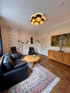 ein Wohnzimmer mit einem schwarzen Ledersofa und einem Tisch in der Unterkunft Haus Hohenzollern & Haus 'Ambiente in Bad Bertrich
