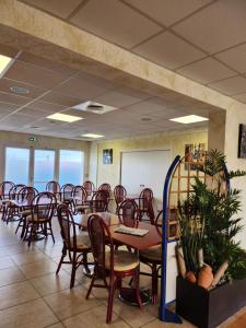 a conference room with tables and chairs and a whiteboard at Relais De La Grange in Nort-sur-Erdre