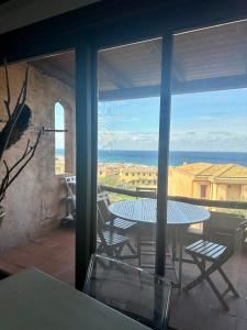 Blick auf eine Terrasse mit einem Tisch und Stühlen in der Unterkunft Prezioso appartamento con vista mozzafiato - Casa Enrica in Castelsardo