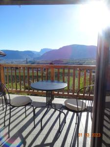 een tafel en stoelen op een balkon met uitzicht bij Panoramaterrace, Wein & relax in Appiano Sulla Strada Del Vino