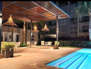 un patio con tavolo, sedie e piscina di Blue Coast Apartment - Vibe Dominicus a La Laguna