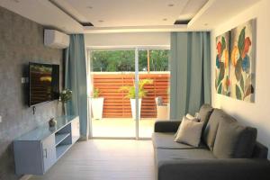 un soggiorno con divano e porta scorrevole in vetro di Blue Coast Apartment - Vibe Dominicus a La Laguna