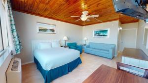 1 dormitorio con 1 cama y 1 sofá azul en Ocean Landings Resort, en Cocoa Beach