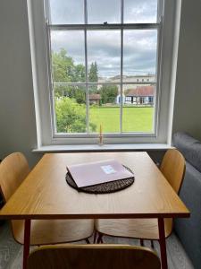 a table with a laptop on it in front of a window at Apartment 3 St Georges in Cheltenham
