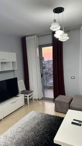 Tirana Apartments Onea's في تيرانا: غرفة معيشة مع أريكة وتلفزيون