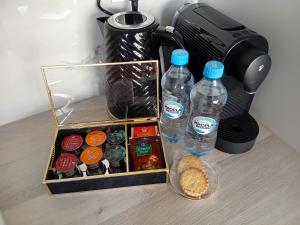 a coffee maker with two bottles of water and food at NOWY Apartament Pełen Życia in Białystok