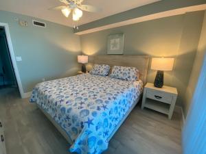 a bedroom with a bed with a blue comforter and two lamps at Lover's Key Resort by Check-In Vacation Rentals in Fort Myers Beach