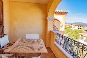 a balcony with a wooden table and chairs at [Olbia 15 minutes] Enchanting sea view in Olbia