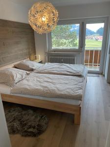 a bedroom with a large bed and a chandelier at Ferienwohnung Gipfelblick in Oberstaufen
