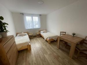 Zimmer mit 2 Betten und einem Tisch in der Unterkunft Apartmán Strážný 7 in Strážný