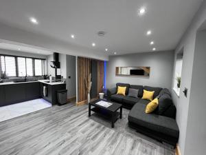 a living room with a couch and a kitchen at Entire Two Bedroom Guest House & Free Parking in Nottingham