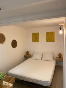 1 cama blanca en una habitación con 2 cuadros en la pared en Villa con piscina privada Costa brava, en Maçanet de la Selva