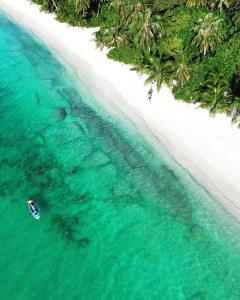 an aerial view of a beach with a boat in the water at Island scuba inn in Dhangethi