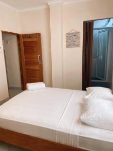 Schlafzimmer mit einem großen weißen Bett und einer Holztür in der Unterkunft BlackPoint in Ballenita