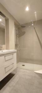 a white bathroom with a shower and a sink at Modern Penthouse with Amazing Sea Views in the Heart of Javea Old Town in Jávea