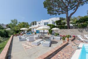 un patio con sillas y sombrillas junto a una piscina en Suite Villa Carolina, en Capri