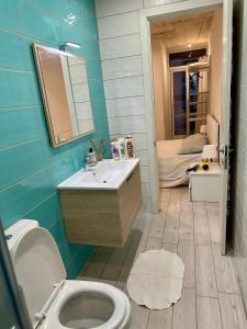 a bathroom with a sink and a toilet and a bed at Heart of the Paceville Modern Apartment! in St. Julianʼs