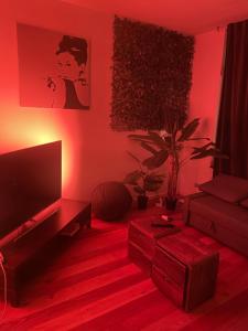 a living room with a television and red lighting at Appartement spacieux pour un séjour inoubliable in Brussels