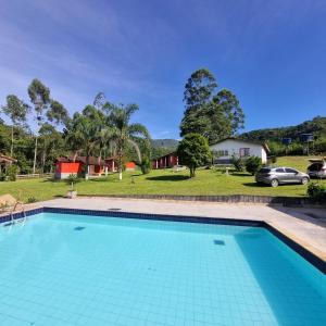 a swimming pool in front of a house at Pousada do Tie - Rio Preto MG in São José do Rio Preto