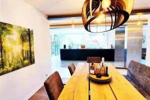 uma sala de jantar com uma mesa de madeira e cadeiras em Bruce's Countryhouse em Niederweis