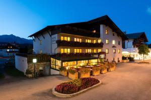 Un bâtiment avec un bouquet de fleurs devant lui dans l'établissement Hotel Diana, à Seefeld in Tirol