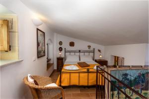 una camera da letto con un letto e una sedia in una stanza di Appartamenti Le Maioliche a San Vito lo Capo