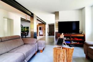 uma sala de estar com um sofá e uma televisão de ecrã plano em Bruce's Countryhouse em Niederweis