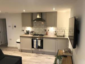 uma cozinha com um lavatório e um fogão forno superior em Apartment 1 St Georges em Cheltenham