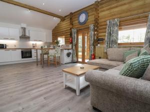ein Wohnzimmer mit einem Sofa und einem Tisch in der Unterkunft Redwood Lodge in Ellesmere