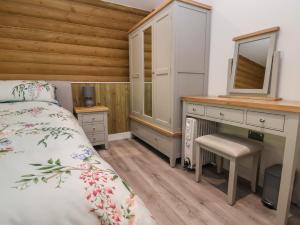 a bedroom with a bed and a desk with a mirror at Redwood Lodge in Ellesmere