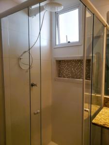 a shower with a glass door in a bathroom at Apto 3 quartos na Praia do Morro wifi 300Mb vista para o mar 2vagas garagem 1 rua da da praia in Guarapari